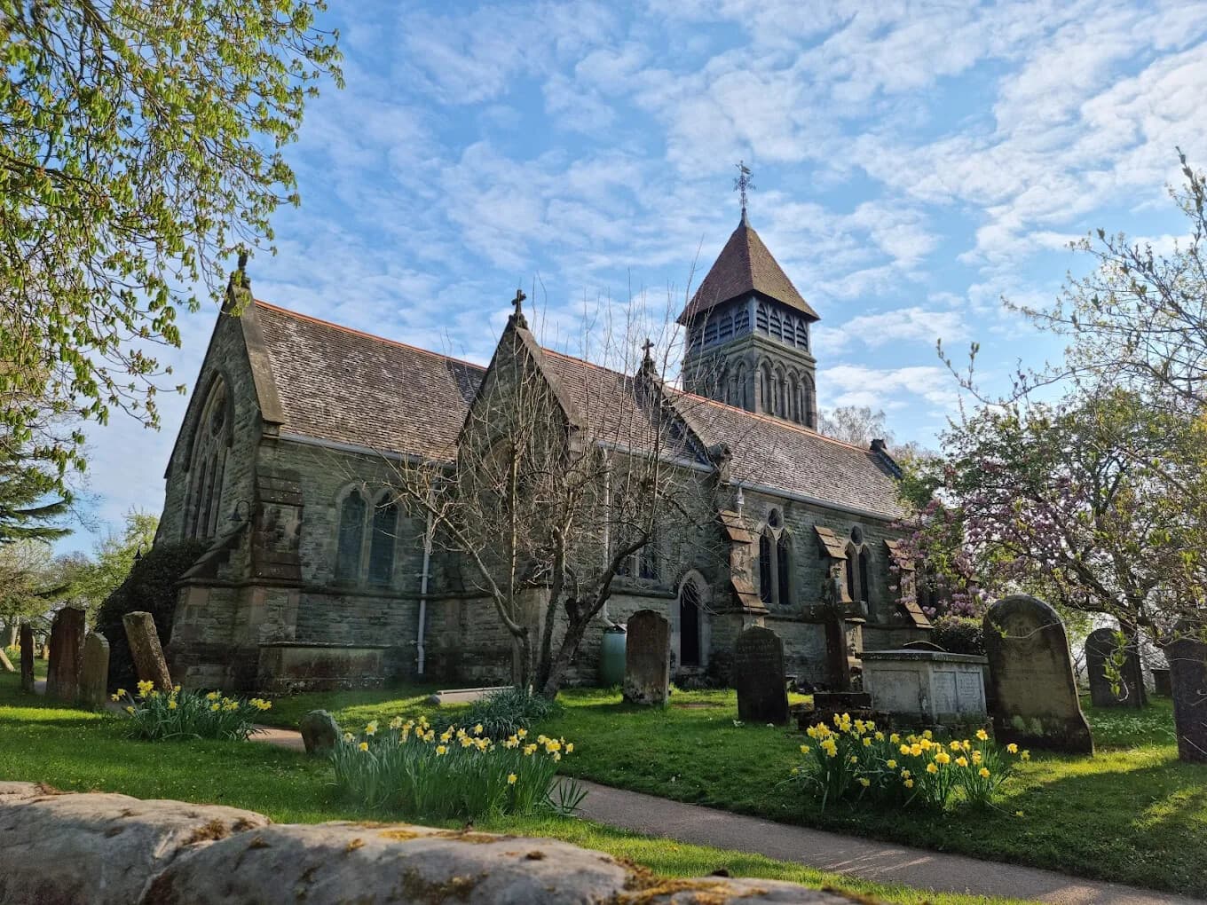 St James the Great in spring, with daffodils in the churchyard